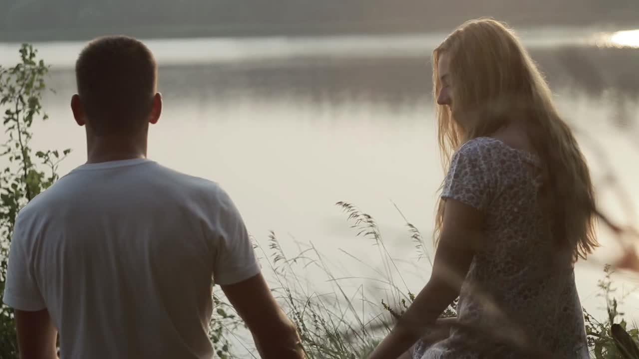 Couple Resting On River Bank. Smiling couple resting on river bank in nature