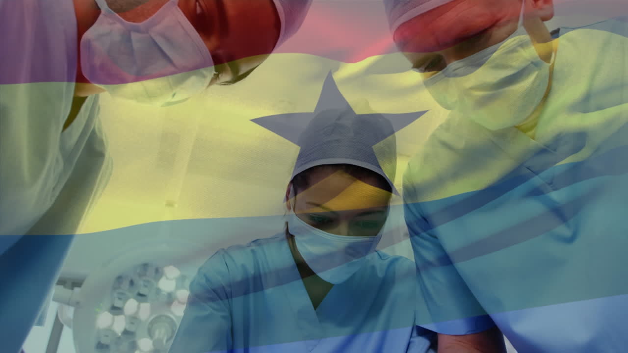 Animazione di una bandiera del Ghana che sventola su uno sfondo di un team eterogeneo di chirurghi che esegue un'operazione in ospedale.