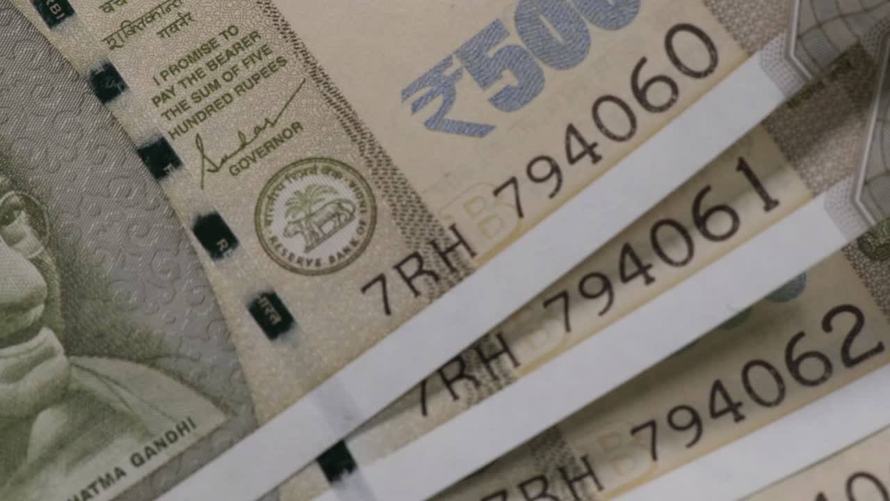 Close-Up of Stacked Indian 500 Rupee Notes with Visible Serial Numbers, RBI emblem and Security Thread. stable shot, 4k.