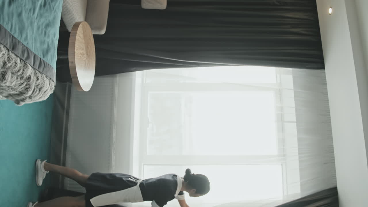 Cameriera ai piani che apre le tende in un appartamento d'hotel