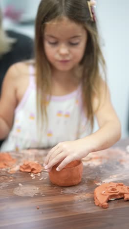 young girl making pottery