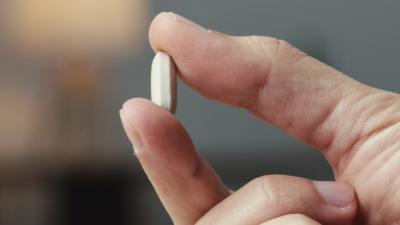 la mano sostiene una píldora