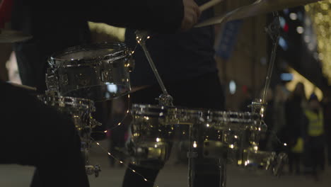 close up of drummer plays drums in downtown at night