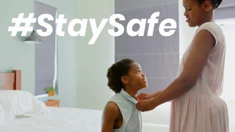 african american woman with her daughter at home with words stay safe during coronavirus pandemic