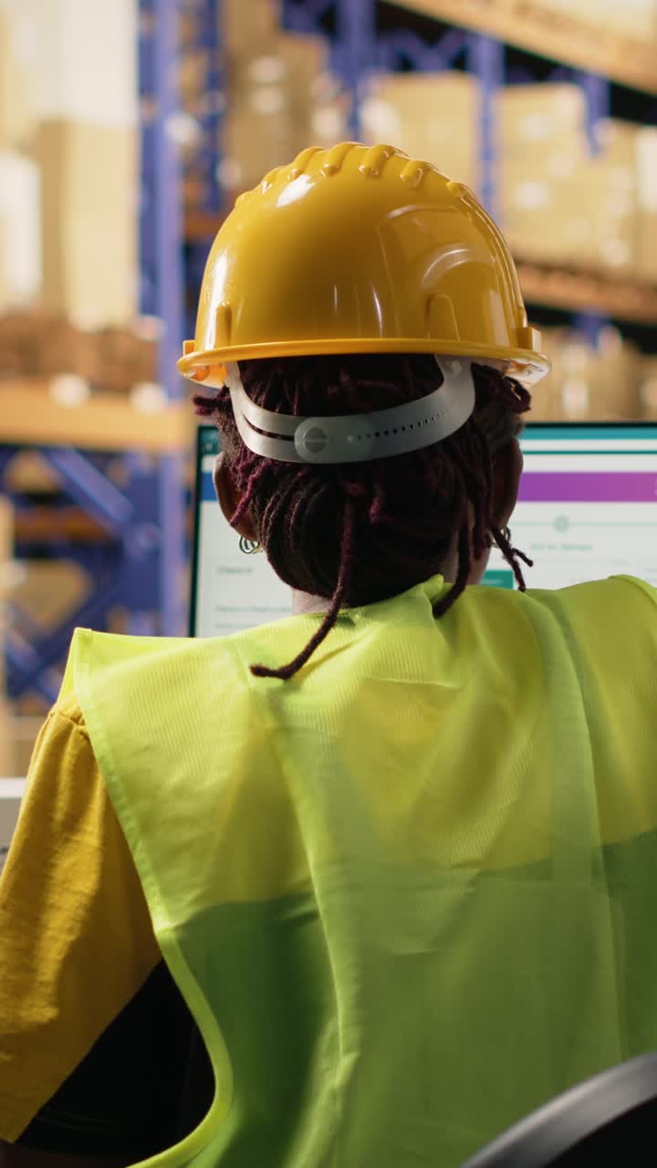 Vertical Video African american female working in logistics hub with tracking info