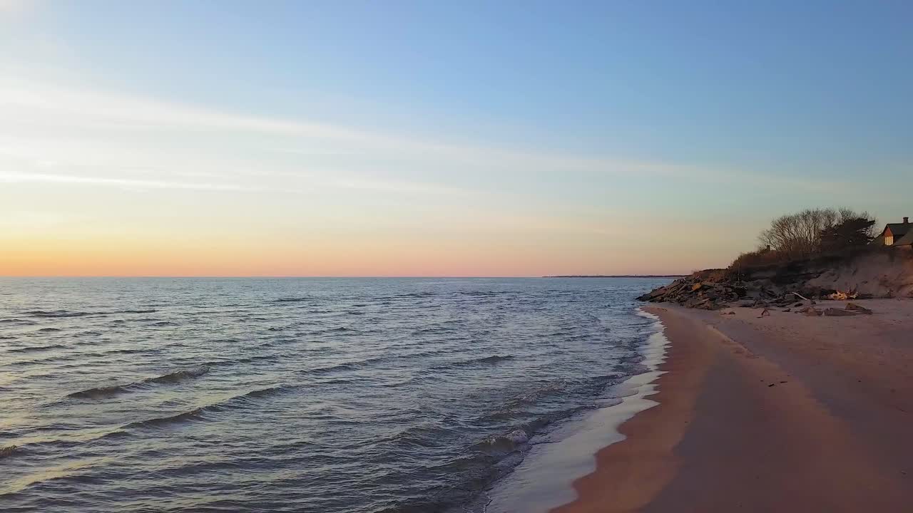 vista aérea de la costa del mar báltico en una tarde soleada, hora dorada, dunas escarpadas de la costa dañadas por las olas, pinos rotos, erosión costera, cambios climáticos, tiro de drones de gran angular bajo avanzando