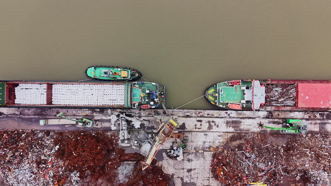 Buque de carga en un astillero cargando mercancías cerca de una vía fluvial.