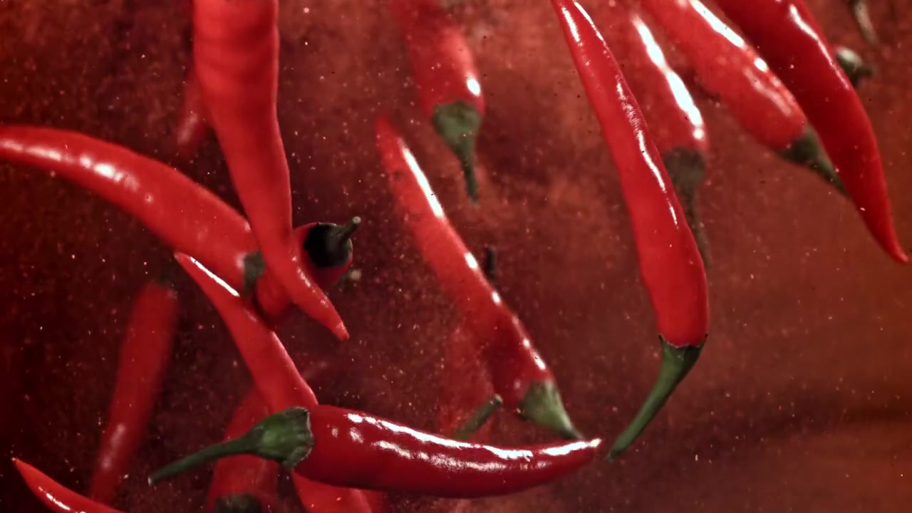 Red Chili Peppers Falling Through Red Spice Powder
