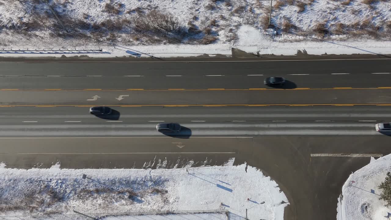 눈 인 풍경으로 둘러싸인 시골 고속도로에서 자동차를 운전하고, 공중 촬영을 슬라이딩합니다.