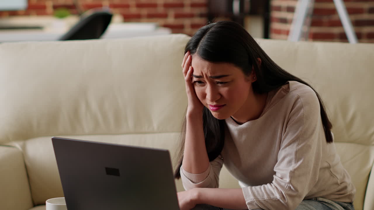 Stressed woman using laptop at home