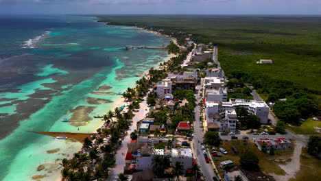 Toma-Cinematográfica-De-Drones-De-La-Ciudad-Turística-Costera-De-Mahahual-Mexico,-Hermosa-Agua-Clara-Del-Océano