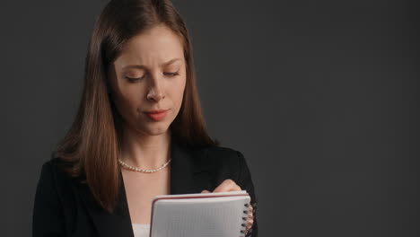 woman in business attire taking notes