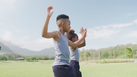 video de escolares afroamericanos felices dando los cinco en el campo después de un partido de fútbol