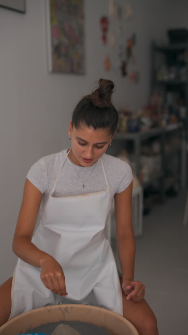 Young Woman Crafting Pottery on a Wheel
