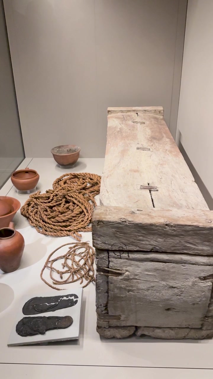 Una lenta panoramica della telecamera attraverso antichi manufatti egizi, inclusi una bara di legno e ceramiche.