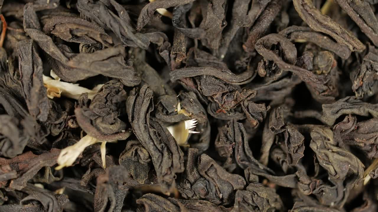 hojas de té negro de cerca. rotación de bucle