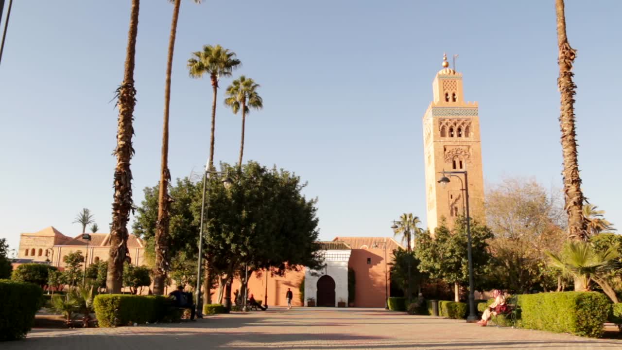 hermosa mezquita koutoubia en marrakech marruecos con un hombre caminando hacia la mezquita