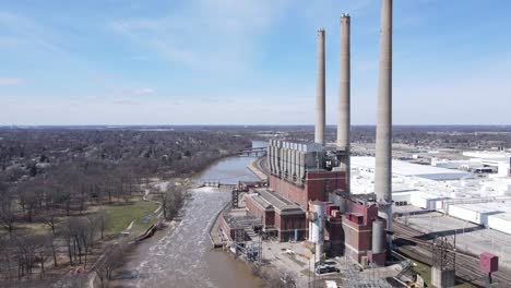 Abandoned-coal-power-plant-on-river-coastline,-aerial-drone-view