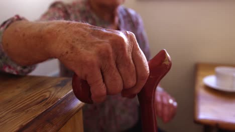 mujer levantándose de la silla en la cocina en casa 4k