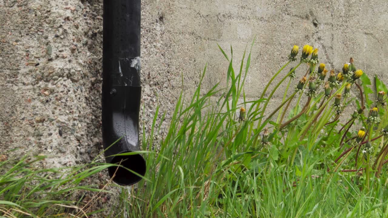 Acqua che Scorre da un Tubo di Scarico su un Muro Esterno