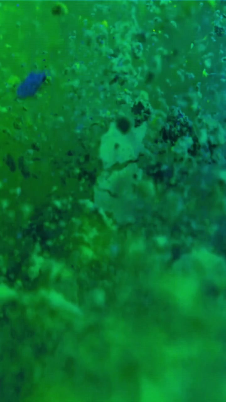 Fluido verde astratto con particelle fluttuanti al rallentatore