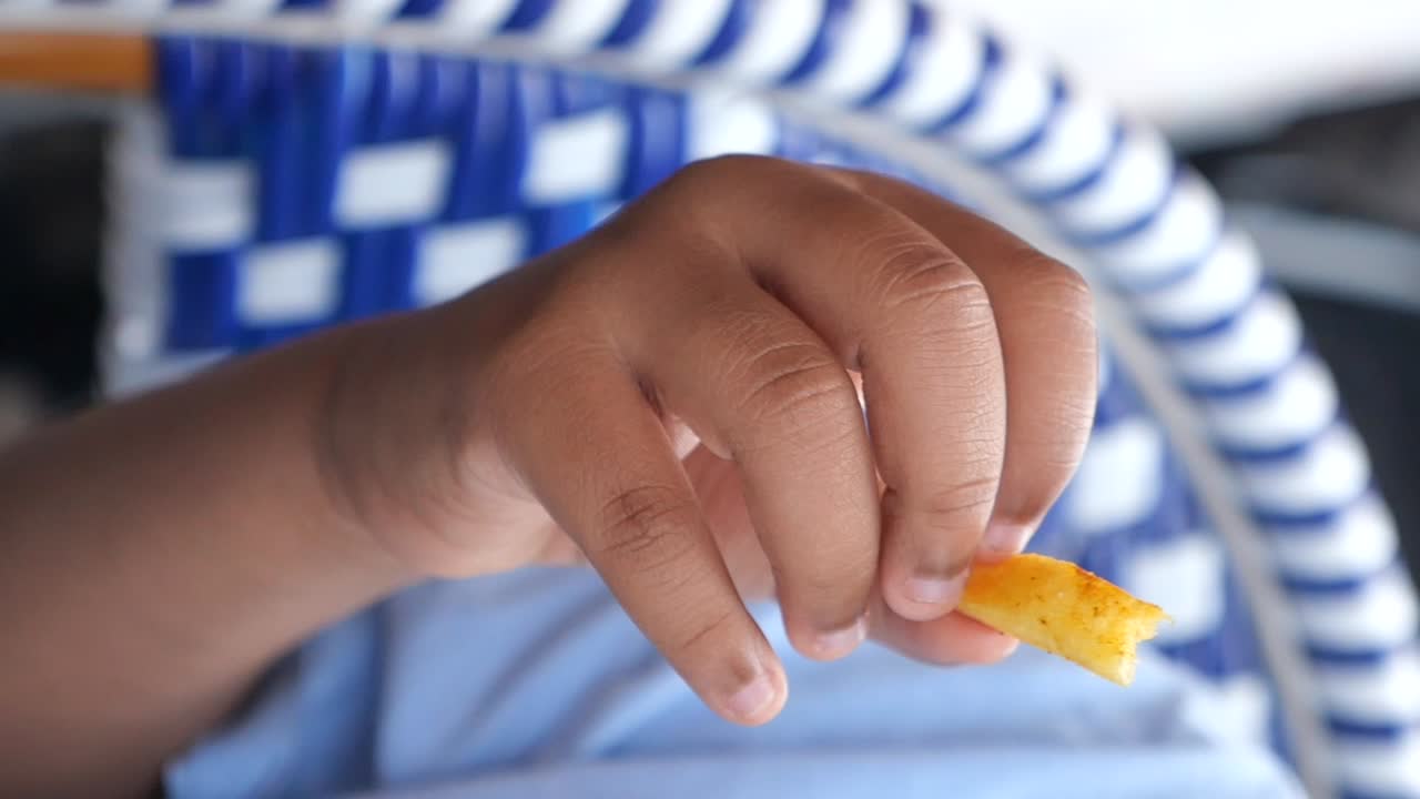 Close-up of a hand holding a french fry