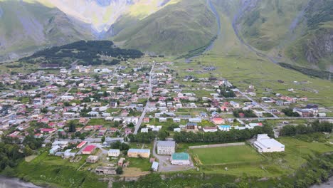 Una-Vista-Aérea-De-Una-Ciudad-Rodeada-De-Exuberantes-Colinas-Verdes