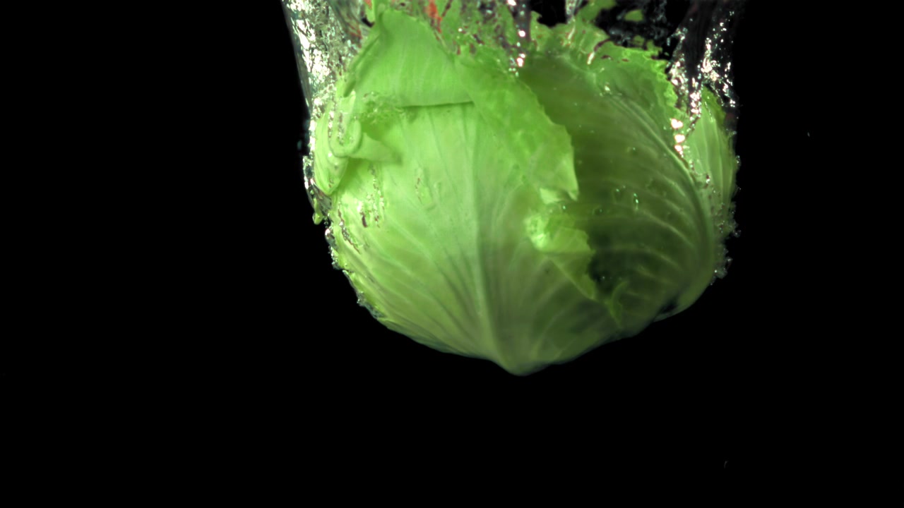 Fresh Green Cabbage Falling into Water in Slow Motion