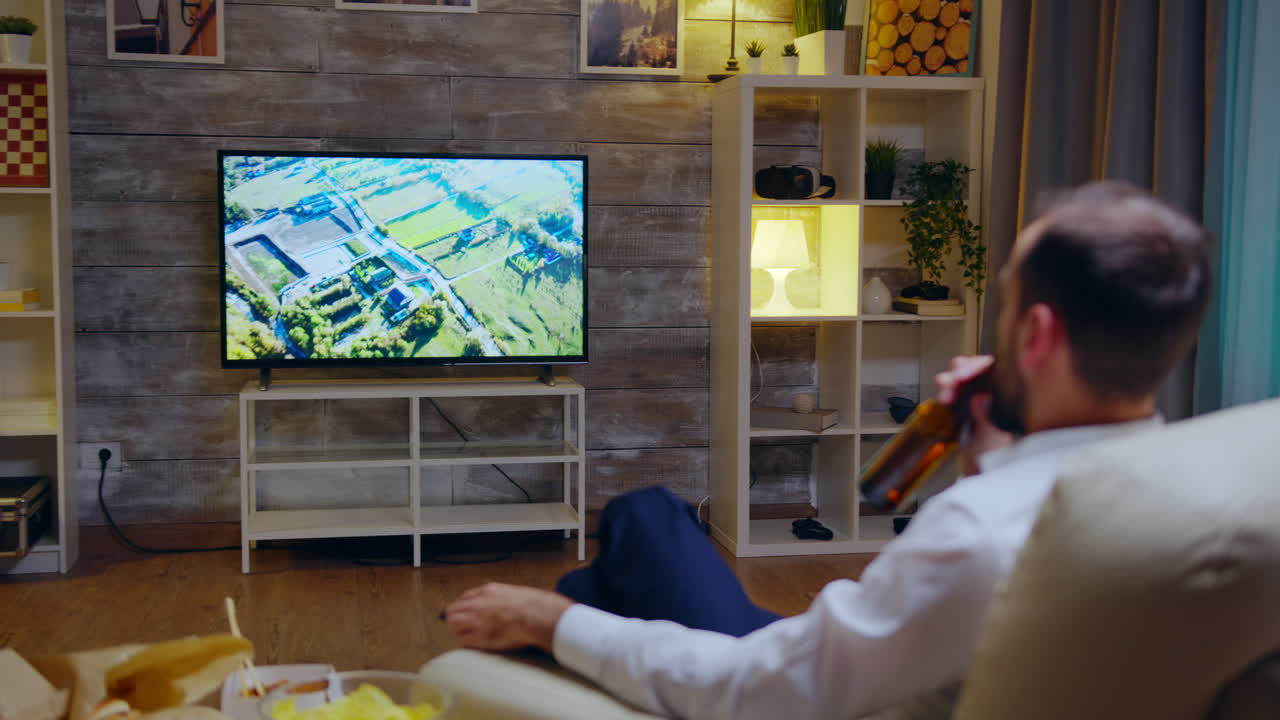 Back view of overworked entrepreneur watching a documentary