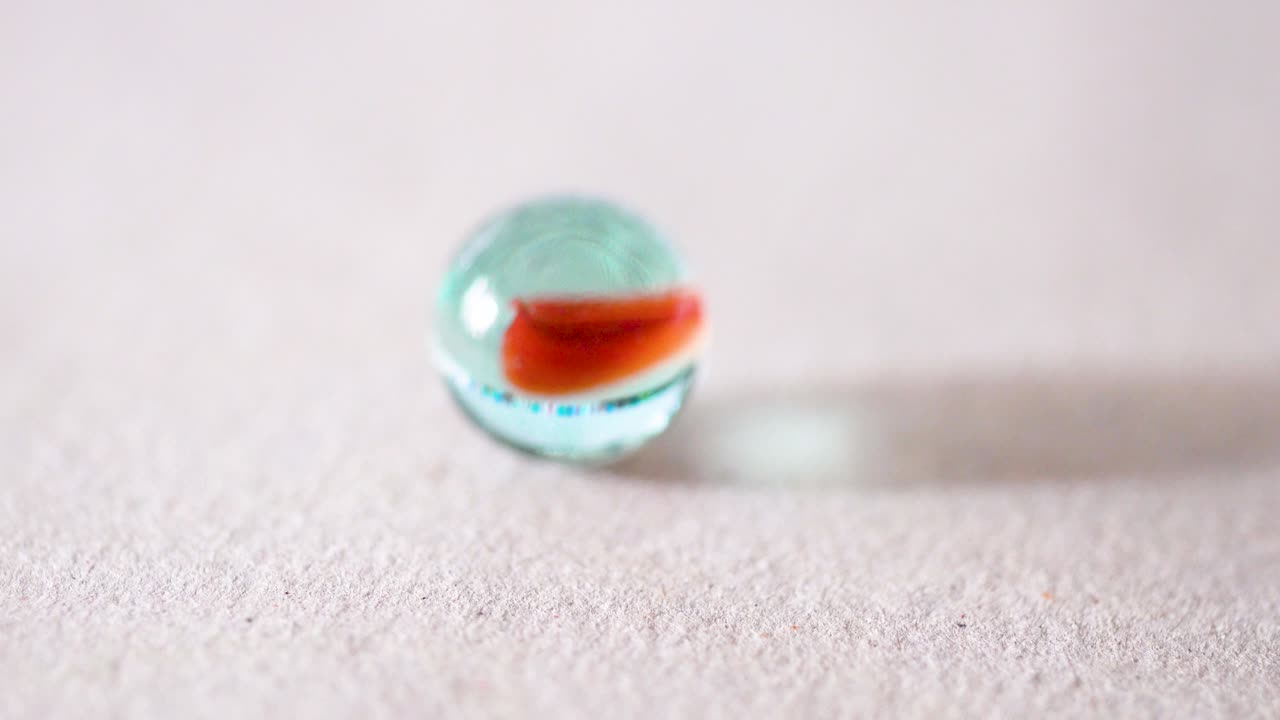 juego tradicional de canicas de vidrio de colores, objetivo de impacto, memoria infantil, cámara lenta