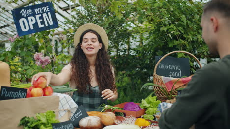 customer paying at a farmer's market stall in a greenhouse