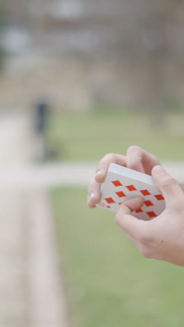 man performing card trick outdoors