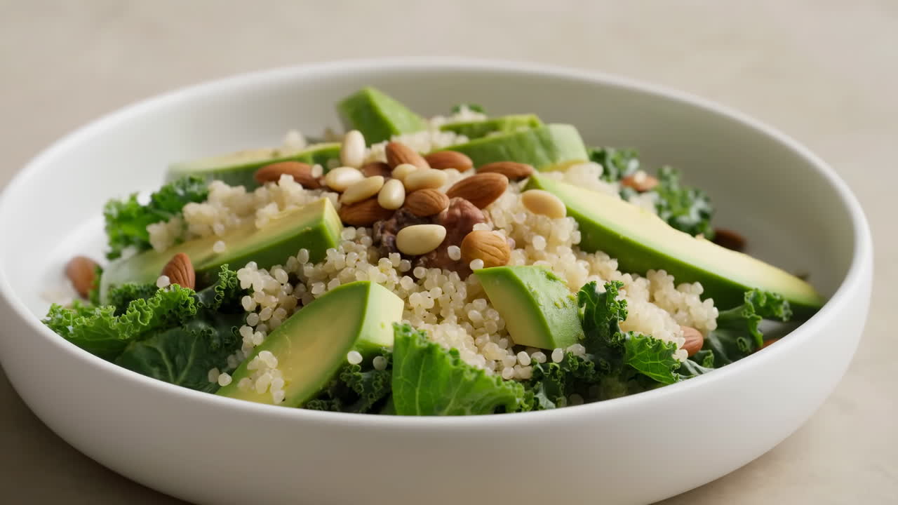Strøing av nøtter over en frisk salat med quinoa, avokado og grønnkål