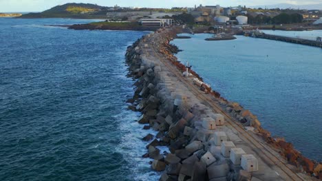 vista aérea de las olas de la playa rompiendo contra la barrera del rompeolas - port kembla, wollongong, nsw, australia