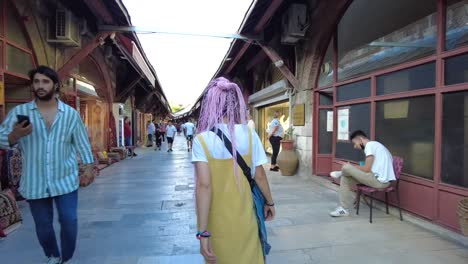 a girl with pink dreadlocks walks along the bazaar walkway in istanbul, turkey, adding a unique and colorful touch to the vibrant marketplace scene.