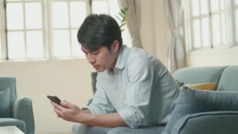 male using smartphone in living room, video in 4k