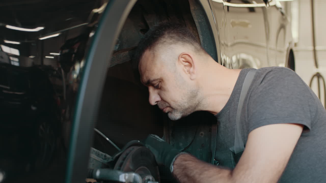 mecánico trabajando en los frenos de un coche