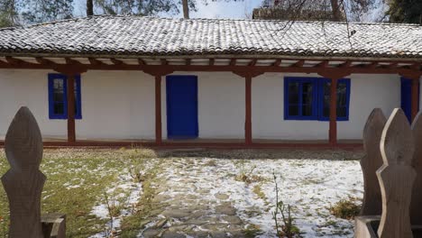 old house with blue entrance door and windows from 19th century on winter