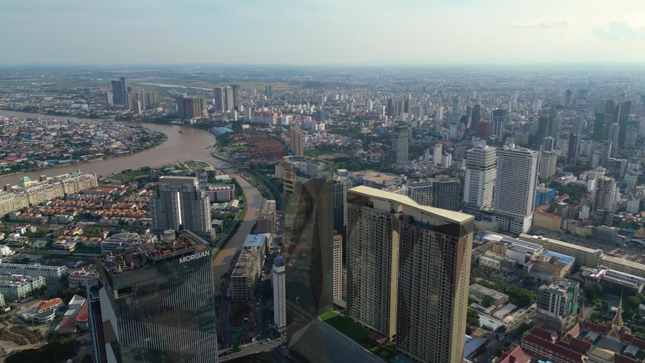 Drone shot of densely populated Phnom Penh city skyline, skyscrapers alongside river