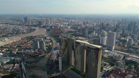 drone shot of densely populated phnom penh city skyline, skyscrapers alongside river