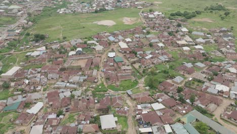 Pequeña-Ciudad-Aérea-Con-Techos-Marrones,-Revelación-Inversa-De-Arriba-Hacia-Abajo