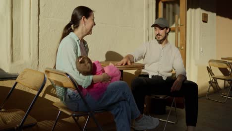 happy family sitting at a cafe table