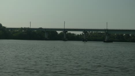 Puente-Ferroviario-Sobre-Un-Río-Tranquilo,-Exuberante-Vegetación-En-Las-Orillas,-Entorno-Sereno,-Día-Despejado