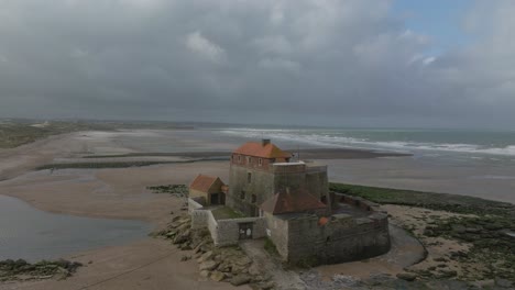 A-bit-of-sun-light-hitting-the-historical-fort-at-Ambleteuse-during-a-stormy-summer-day-at-low-tide