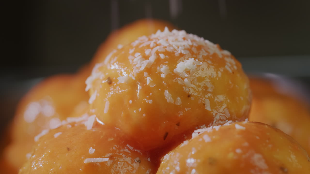 apetitosas albóndigas en salsa de tomate salpicadas de queso rallado. video 4k