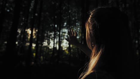 Mystisches-Mädchen-Im-Wald,-Das-Ihre-Hand-Durch-Bäume-Zum-Licht-Hält