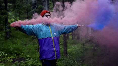 hombre liberando humo colorido en el bosque