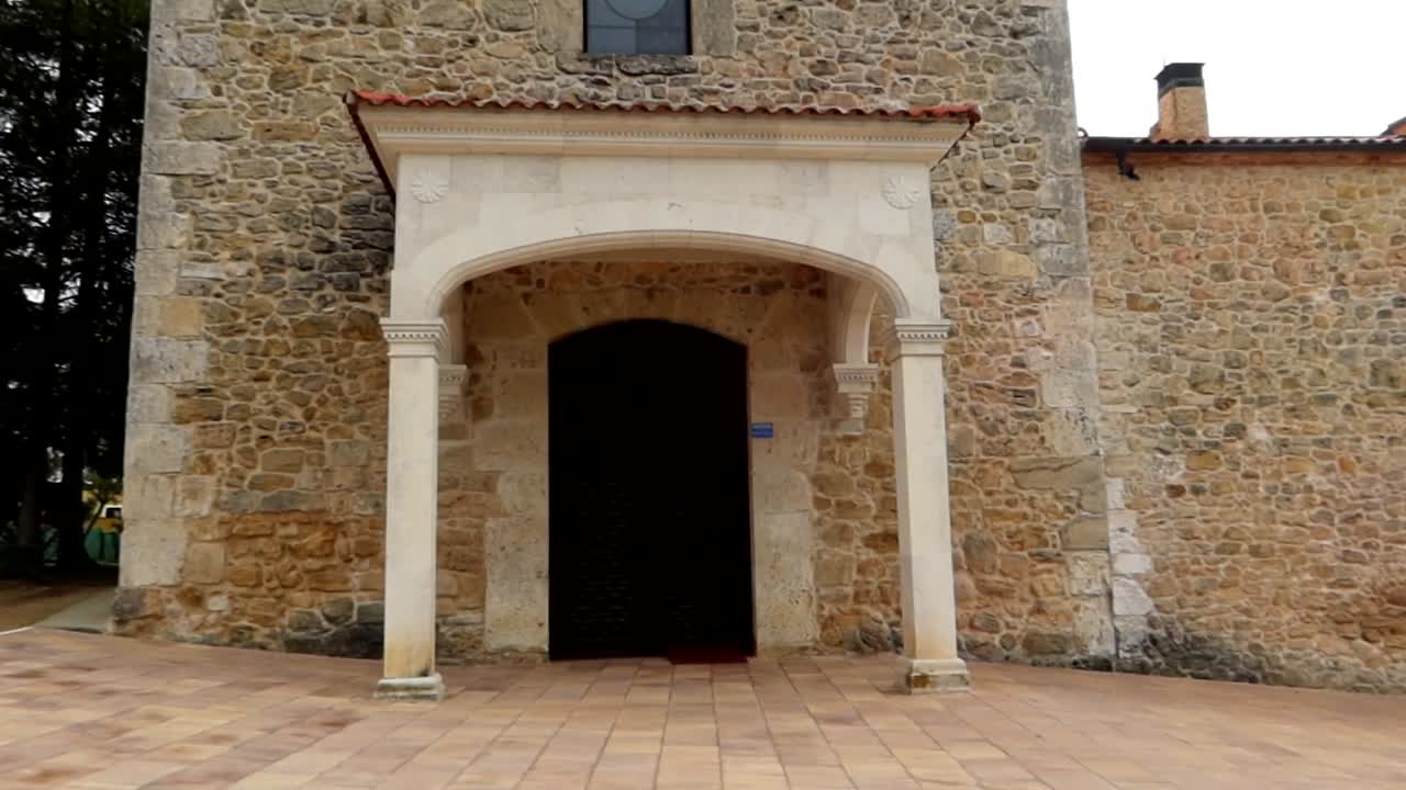 White stone facade with porch and tall door of Santuario Virgen de las Vi&ntilde;as, Aranda de Duero