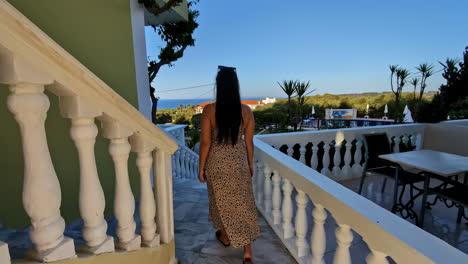 woman on balcony overlooking scenic resort in slow motion follow shot