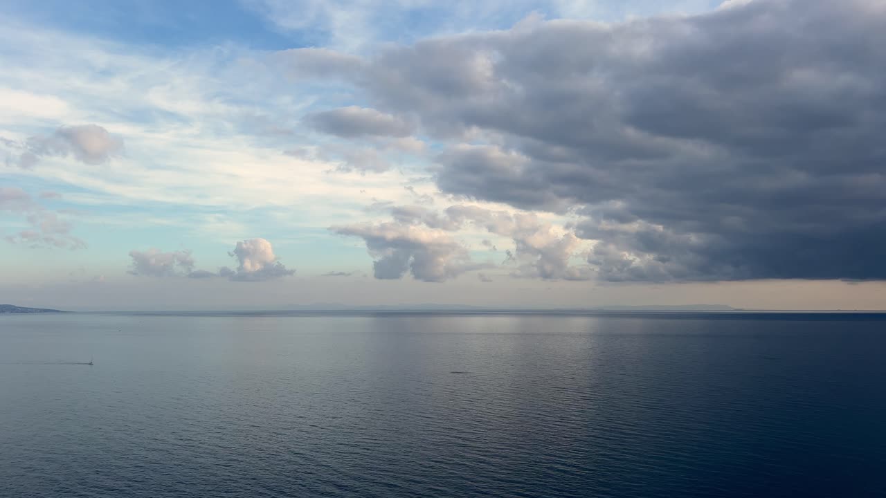 평온한 바다 위에서 땅을 향해 굴러가는 어두운 구름의 타임스